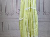 a yellow dress on a mannequin stand on a wooden floor