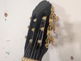 a close up of a guitar head on a wall