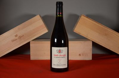 a bottle of wine sitting on a table next to two wooden boxes