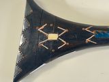 a black horn with a blue and white design on it