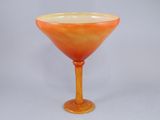 un verre orange à bord jaune posé sur une surface blanche