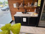 a glass table with a vase of flowers on it in front of a refrigerator
