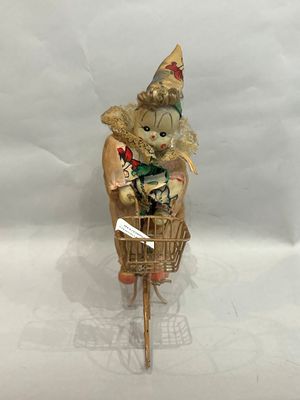 a figurine of a clown riding a bicycle