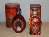une bouteille de brandy à côté d'un bac contenant des boîtes de conserve