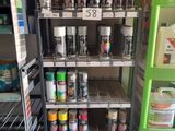 many cans of paint on the shelves in the store