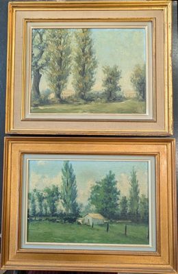 Deux tableaux représentant des arbres sont accrochés au mur d'une pièce.