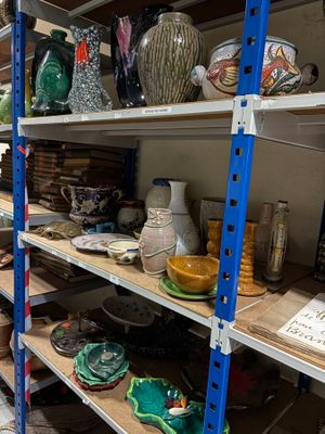 many shelves with vases on them in a store