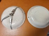 two white plates with silver handles on a wooden table