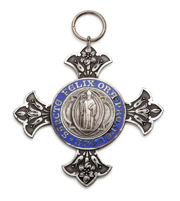 un gros plan d'une croix sur laquelle est accrochée une médaille