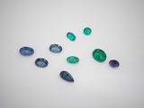a group of green and blue gems on a white surface
