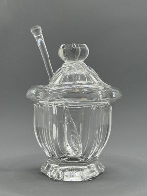 un bocal en verre transparent avec une cuillère et un repose-cuillère posé dessus