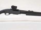 un pistolet jouet posé sur un socle transparent, sur une surface blanche