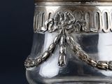 an antique silver plated glass jar with a chain around it