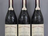 Trois bouteilles de vin sont alignées sur une table en verre