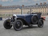 une voiture de collection garée sur un parking devant un grand immeuble