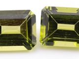 a pair of green and yellow tourmaline gems on a white surface