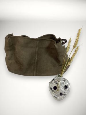 un sac à main en cuir marron contenant une fleur et un vase rempli de blé