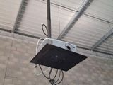 a ceiling mounted projector in the middle of a room