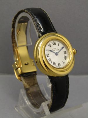 une photo d'une montre-bracelet dorée et noire avec des chiffres romains