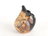 a small vase with a painting on it sitting on a table