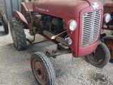 un tracteur rouge qui est garé dans la terre