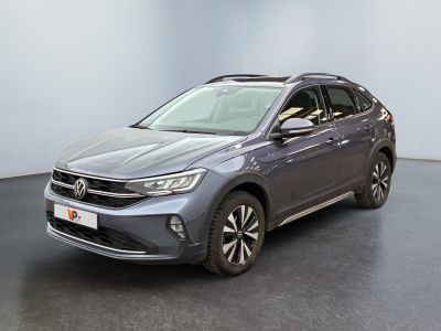 un SUV Volkswagen gris garé dans une pièce au sol noir