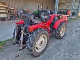 a red tractor that is parked in front of a building