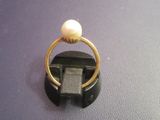 a gold ring with a pearl on top of it