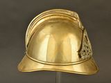 a gold helmet on a stand on a gray background