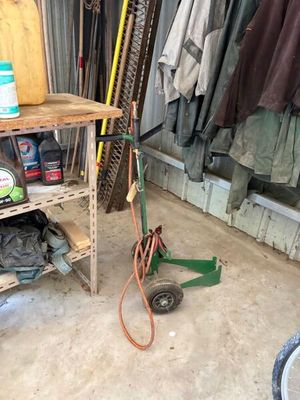 un petit chariot contenant un tuyau et d'autres objets dans un garage