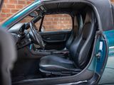 the interior of a car with the door open and the driver ' s seat up