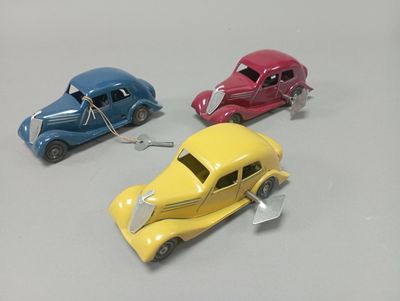 trois voitures jouets assises l'une à côté de l'autre sur une table