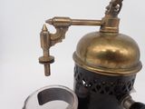 a brass coffee grinder with a magnifying glass on it