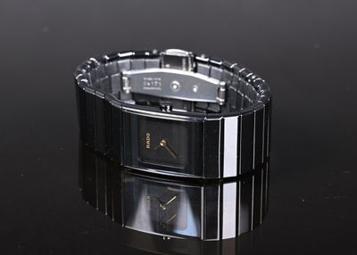 une image d'une montre-bracelet posée sur une surface noire