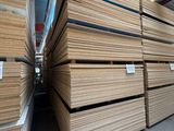 plusieurs piles de panneaux de contreplaqué empilés les uns sur les autres dans un entrepôt