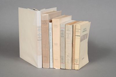 several books are stacked on top of each other on a gray surface
