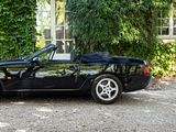 an image of a black sports car parked in front of a house