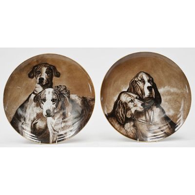 two plates with dogs painted on them sitting side by side