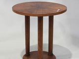 une table ronde en bois à deux pieds, avec un plateau en bois