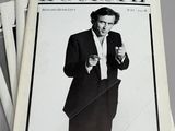 several newspapers stacked on top of each other with a man in a tuxedo