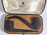 a black pipe in a case on a white table