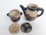 a tea pot and two cups sitting next to each other
