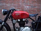 a red and black motorcycle parked next to a brick wall