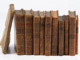 plusieurs vieux livres sont empilés sur une surface blanche
