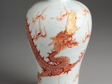 a white and orange vase with a dragon on it
