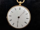 une montre de poche en or avec des chiffres romains sur le cadran