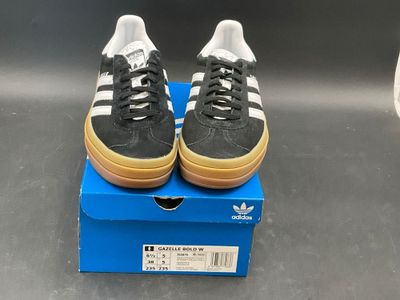 a pair of black and white shoes on a blue box