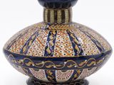 a blue and orange vase sitting on a white surface