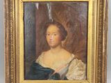 un tableau représentant une femme en robe bleue, dans un cadre doré