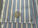 a small coin in the pocket of a dress shirt